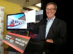 Mayor Jim Watson helps cameramen with their lighting during a campaign announcement about the LRT 2 expansion at his re-election headquarters on Sunday, Sept. 28, 2014. 
JON WILLING/OTTAWA SUN/QMI AGENCY