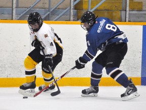 Zach Dow (14) of the Mitchell Bantams battles BCH's Kyle Handy (8) for possession of the puck during WOAA exhibition hockey action Sunday, Sept. 28 in Mitchell. ANDY BADER/MITCHELL ADVOCATE