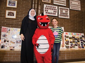 Jennifer Parker (left), dressed as St. Michael's first teacher Sister St. Marie, stands with Dynasty the Dragon and Grade 5 student Mckinney Ettenhofer (right) at 110th anniversary celebration of Roman Catholic education in Pincher Creek. John Stoesser photos/QMI Agency.