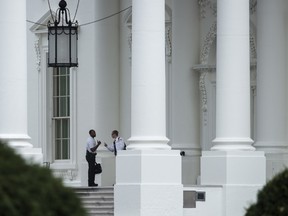 Members of the US Secret Service Uniformed Division talk while standing guard at the north entrance to the White House September 29, 2014 in Washington, DC. (AFP PHOTO/Brendan SMIALOWSKI)