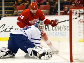 Maple Leafs goalie James Reimer makes a save on Red Wings centre Riley Sheahan in Detroit last night. Reimer allowed two goals on 16 shots. (USA Today Sports)