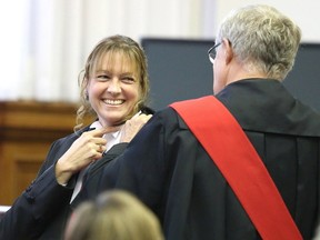 Gino Donato/The Sudbury Star 
Justice Karen Lische smiles as Justice Richard Humphrey puts on her judge's sash during her swearing-in ceremony at the Sudbury Courthouse on Monday. Lische was sworn in as a judge of the Ontario Court of Justice.