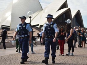 Police patrol in front of the Sydney Opera House in Sydney on September 24, 2014.   AFP PHOTO/Peter PARKS