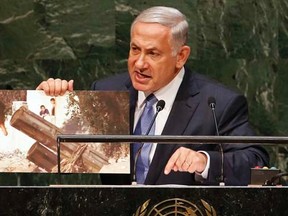 Israel's Prime Minister Benjamin Netanyahu holds up a photograph as he addresses the 69th United Nations General Assembly at the UN headquarters in New York September 29, 2014.  REUTERS/Mike Segar