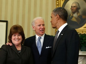 U.S. President Barack Obama, right, stands with U.S. Secret Service agent Julia Pierson, left, after she is sworn in as the first woman Director of the Secret Service by Vice President Joe Biden, centre, in the Oval Office of the White House in Washington in this March 27, 2013 file photo. (REUTERS/Larry Downing)