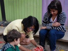 Olivia Chow builds a sand castle with child-care worker Priya Sethi and two-year-old Albor. (SHAWN JEFFORDS/Toronto Sun)