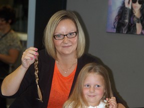 Intrigue Hair Lounge's Mori-Lynn Haggith shows off the hair she cut off of Tatum Waring, 6, of Port Lambton on Sept. 25. Waring donated the hair to the Locks of Love charity, which takes the hair to make wigs for cancer patients who have lost their hair through their treatments.