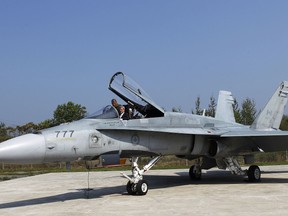 Canadian Prime Minister Stephen Harper sits in the cockpit of a CF-18 fighter jet as he talks with Major Daniel Dionne in Mirabel, Quebec, September 1, 2010. (REUTERS/Shaun Best)