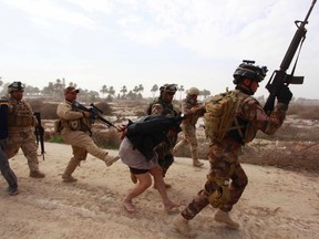 Personnel from the Iraqi security forces arrest suspected militants of the al Qaeda-linked Islamic State in Iraq and the Levant (ISIL), during clashes with Iraqi security forces in Jurf al-Sakhar, 60 km (40 miles) from the capital. South of Baghdad, ISIL militants killed at least eight soldiers in overnight clashes in Jurf al-Sakhar, 60 km (40 miles) from the capital, army and police sources said.  REUTERS/Alaa Al-Marjani