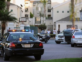 A police vehicle and residents are seen at the crime scene where mayor of Bell Gardens, California Daniel Crespo was shot, at a condominium in Bell Gardens, California September 30, 2014. Crespo was shot to death by his wife on Tuesday in an apparent domestic dispute, and his spouse has been detained by investigators, according to the county sheriff's department. The shooting stemmed from an afternoon quarrel between Crespo, 45, and his wife, Lavette, 43, that escalated when their 19-year-old son, Daniel Jr., intervened, sheriff's spokeswoman Crystal Hernandez said.      REUTERS/Bob Riha