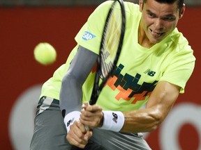 Milos Raonic hits a return to Bernard Tomic during their men's singles match at the Japan Open in Tokyo, Sept. 30, 2014. (TOSHIFUMI KITAMURA/AFP)