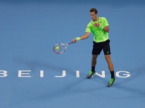 Vasek Pospisil returns the ball during his men's singles match against Novak Djokovic at the China Open in Beijing, Wednesday, Oct. 1, 2014. (Jason Lee/Reuters)
