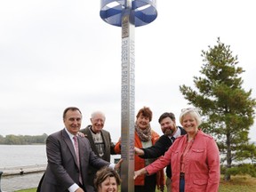 Rev. Anne-Marie Jones, centre, and Mayor of Belleville, Ont. Neil Ellis, left, dedicate the city's sixth peace pole at East Bayshore Park at the bottom of Herchimer Avenue Wednesday, Oct. 1, 2014. Jones and Ellis are flanked here by Jones' parents Robert and Marie, her husband David Cooper and her sister Sue Gray. - JEROME LESSARD/THE INTELLIGENCER/QMI AGENCY