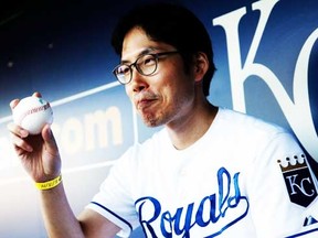 Kansas City Royals fan Lee Sung-woo of Korea shows off a signed baseball while sitting in the dugout prior to the game against the Oakland Athletics at Kauffman Stadium on August 11, 2014 in Kansas City, Missouri. (Jamie Squire/Getty Images/AFP)