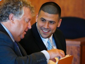 Former NFL player Aaron Hernandez (R) smiles at his lawyer, James Fee, during a hearing at Bristol County Superior Court in Fall River, Massachusetts July 9, 2014. (REUTERS)