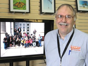 Ted Smith, who will be leading one of two photo walks in Kingston as part of the annual Worldwide Photo Walk on Oct. 11, stands in front of a screen showing images from last year's walk. (Michael Lea/The Whig-Standard)