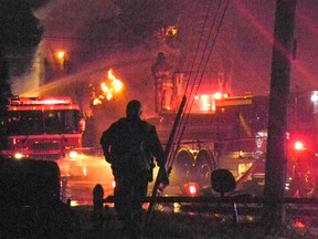 A city police officer is silhouetted by fire emergency vehicle lights beside a two-house fire near the corner of First and Alice streets, which residents were able to flee,on Wednesday evening.
GREG PEERENBOOM/CORNWALL STANDARD-FREEHOLDER/QMI AGENCY