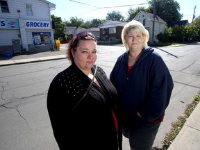 Sisters Bobbie-Jo Thompson, left, and Billy-Jo Hollywood at the corner of Patrick and John Streets in Kingston on Friday where their brother, Dennis Thompson, was involved in a crash in July. (Ian MacAlpine/The Whig-Standard)