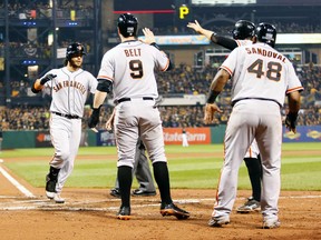 San Francisco Giants shortstop Brandon Crawford (left) celebrates his grand slam against the Pittsburgh Pirates with teammates during the NL wild card game at PNC Park in Pittsburgh, Oct. 1, 2014. (CHARLES LeCLAIRE/USA Today)