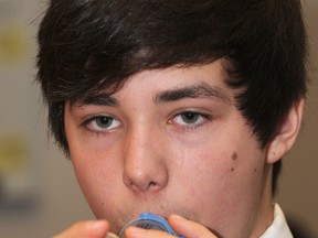Bram Bouma, 12, takes an asthma inhaler at the Rockyview Hospital in Calgary in this 2012 file photo. People with pre-existing respiratory conditions are among the most at risk of serious harm from the Enterovirus D68.