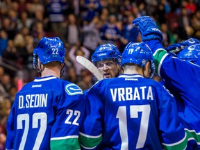Vancouver Canucks forward Daniel Sedin (22), and  forward Henrik Sedin (33), and forward Radim Vrbata (17)  celebrate Vrbata's goal during the third period of a preseason game at Rogers Arena. (Bob Frid-USA TODAY Sports)