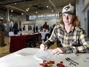 Job seeker Cameron Philips, 18, of Trenton, Ont. fills out a job application at the Quinte Region Career and Training Fair at Quinte Sports and Wellness Centre in Belleville, Ont. Thursday. - JEROME LESSARD/THE INTELLIGENCER/QMI AGENCY