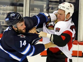 Winnipeg Jets forward Anthony Peluso (14) fights Ottawa Senators forward Chris Neil (25) during the third period at MTS Centre in a preseason game. (Bruce Fedyck-USA TODAY Sports)