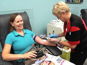 Penny Nash makes her 55th blood donation at the Canadian Blood Services clinic on Gardiners Road, helped by phlebotomist Fran Mack. The organization is currently making an urgent appeal for more donors to fill up its  inventory. (Michael Lea/The Whig-Standard)