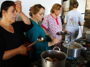 Displaced Iraqi Christian women who fled from Islamic State militants in Mosul cook for refugees living at a mall still under construction, which is now used as a refugee camp in Erbi. (Ahmed Jadallah/Reuters)