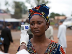 A health worker checks the temperature of a woman entering Mali from Guinea at the border in Kouremale October 2, 2014. The worst Ebola outbreak on record was first confirmed in Guinea in March but it has since spread across most of Liberia and Sierra Leone, killing more than 3,300 people, overwhelming weak health systems and crippling fragile economies. REUTERS/Joe Penney