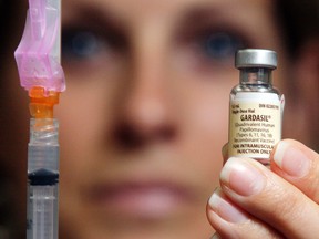 A public health nurse holds a vile of the HPV vaccine.