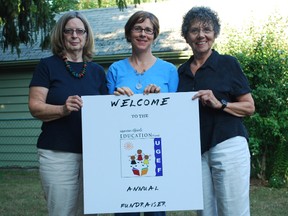 Mary Edgar of Sparta, left, Nancy Whittingham of St. Thomas and Gloria Thomson of London hold a sign advertising a fundraiser for the Ugandan Girls Education Fund, an organization they created. The group plans to hold one fundraiser a year to support education for Ugandan girls. 

File photo