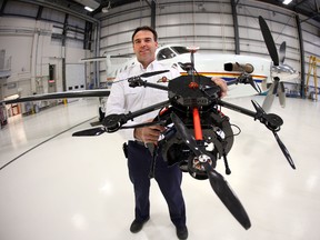 RCMP Edmonton Air Section Base Manager Mark Hovdestad holds a drone in their hanger at the Edmonton International Airport in Edmonton, Alberta, on October 1, 2014. (Perry Mah/Edmonton Sun/QMI Agency)