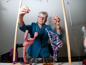 Lisa Figge, a Queen's University PhD candidate, with her puppets in an exhibition at the Isabel Bader Centre in Kingston on Friday.(Ian MacAlpine/The Whig-Standard)