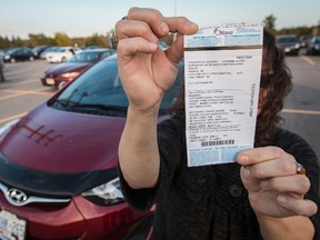 Diana Arthurs holds the parking ticket she received at the Eagleson Road Park N Ride lot. October 3, 2014. Errol McGihon/Ottawa Sun/QMI Agency