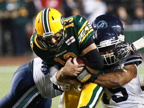 Argos DT Cleyon Laing, right, tackles Mike Reilly during a game at commonwealth Stadium last fall. (Codie McLachlan, Edmonton Sun)