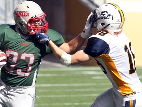 Winnipeg Rifles running back Blair Mattes (left) breaks a tackle by Edmonton Wildcats Kael Schryver during Canadian Junior Football in Winnipeg, Man. Sunday September 22, 2013.