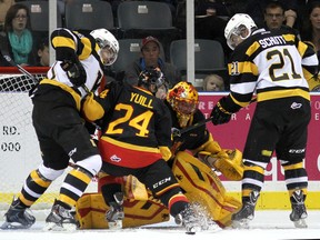 Kingston Frontenacs Conor McGlynn, left, and Sam Schutt look for the puck in front of Belleville Bulls goalie Charlie Graham and defenceman Alex Yuill during Ontario Hockey League action at the Rogers K-Rock Centre on Friday night. (Ian MacAlpine/The Whig-Standard)
