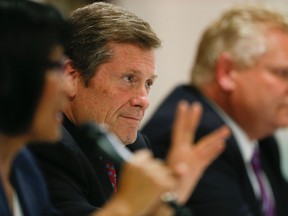 John Tory sits between fellow mayoral candidates Olivia Chow and Doug Ford at a debate at Runnymede United Church on Oct. 3, 2014.
