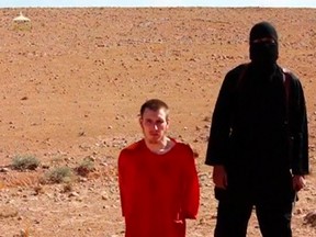 A masked man stands next to a kneeling man identified as U.S. citizen Peter Edward Kassig (L), in this still image taken from video released by Islamic State militants fighting in Iraq and Syria, on October 3, 2014.  REUTERS/Social Media Website via Reuters TV