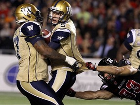 Quarterback Drew Willy #5 of the Winnipeg Blue Bombers runs into teammate Devin Tyler #57 while being tackled by Devin Tyler #57 into of the Winnipeg Blue Bombers in the second quarter during a CFL game at TD Place Stadium on October 3, 2014 in Ottawa, Ontario, Canada. (Jana Chytilova/Freestyle Photography/Getty Images/AFP)