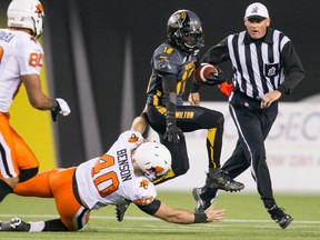 Brandon Banks (right) of the Hamilton Tiger-Cats avoids a tackle from Mike Benson of the B.C Lions last night at Tim Hortons Field. (Geoff Robbins/Reuters)
