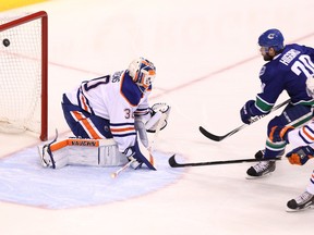 Vancouver Canucks’ Chris Higgins scores on Oilers goalie Ben Scrivens during the first period of their pre-season game at Rogers Arena in Vancouver on Saturday, Oct. 5, 2014. Carmine Marinelli/QMI Agency