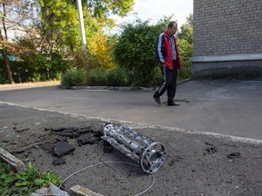 A man walks past a fragment of a missile launched from a Uragan multiple launcher system after recent shelling in Donetsk, eastern Ukraine, Oct. 5, 2014.