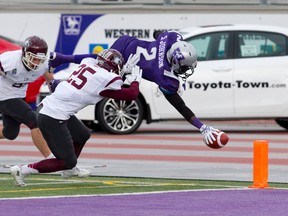 Western Mustangs receiver Shaquille Johnson goes airborne as he scores a touchdown while being tailed by a McMaster Marauders defensive backs Scott Martin and Zach Ismael during their OUA football game at TD Stadium on Saturday. (CRAIG GLOVER, The London Free Press)