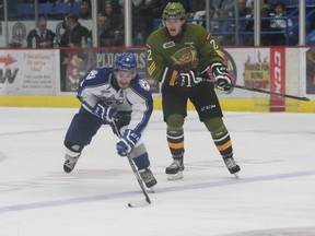 Sudbury Wolves forward Danny Desrochers reaches for a puck with North Bay Battalion's Brenden Miller chasing the play during second-period OHL action at Sudbury Community Arena on Sunday afternoon.