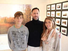 Gregory Ross poses with his kids Sean, 14, and Ciara, 18, at the Sunday opening of his art exhibition, Sketchbook, at Gallery in the Grove. He's one of four artists featured this month at the Bright's Grove gallery. Ross' children are among the subjects in his show that also features photos of places that inspire him. TYLER KULA/ THE OBSERVER/ QMI AGENCY