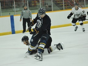 Voyageurs' Michael MacDonald has the puck poked away from him by a diving Stingers player during OUA men's hockey action at Gerry McCrory Countryside Sports Complex. The Voyageurs won 5-2, improving to 2-0 on the season.