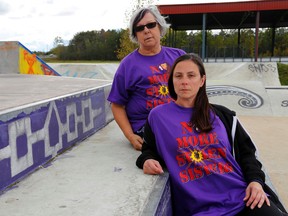 Betty Carr-Braint and daughter Jolie Brant sit near a painting of the Iroquois Confederacy flag after a Sisters in Spirit vigil at Karonhyak'tatye Sports Complex on the Tyendinaga Mohawk Territory, Ont. Saturday, October 4, 2014. It was one of 133 vigils across the country and organizers called for a federal inquiry into the deaths and disappearances of native women.