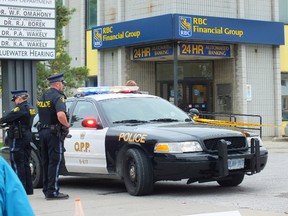 OPP officers stationed outside the RBC Royal Bank branch in Corunna following an armed robbery Monday. Police are searching for a male suspect, believed to be toting a firearm, in connection to the second armed robbery in Lambton County in a little more than two months. (BRENT BOLES, QMI Agency)